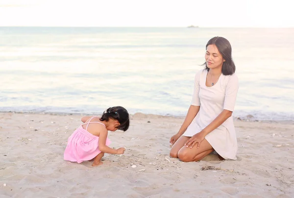 Boldog, szerető család. Anya és lánya gyermek lány játszik a homok a tengerparton — Stock Fotó
