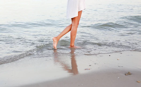 Mujer joven en vestido blanco caminando sola en la playa — Foto de Stock