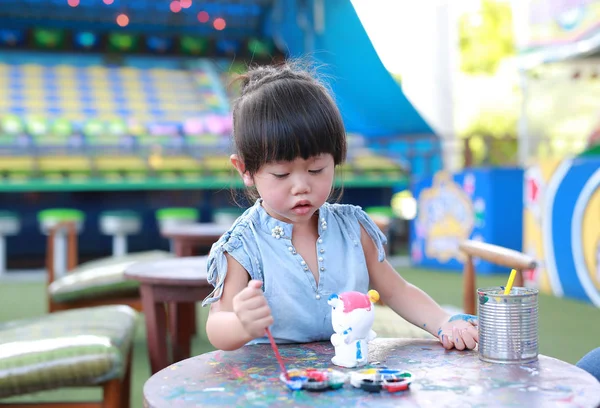 Pintura infantil, Retrato niña divirtiéndose para pintar en estuco muñeca — Foto de Stock