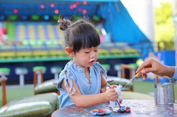 Pintura infantil, Retrato niña divirtiéndose para pintar en estuco muñeca — Foto de Stock