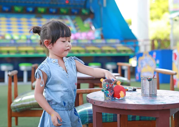 Pintura infantil, Retrato niña divirtiéndose para pintar en estuco muñeca — Foto de Stock