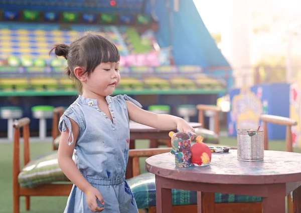 Pintura infantil, Retrato niña divirtiéndose para pintar en estuco muñeca — Foto de Stock