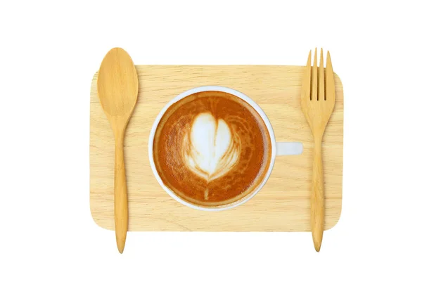 Vista superior de un café con patrón de corazón en una taza blanca sobre un bloque de madera con cuchara y tenedor sobre fondo blanco — Foto de Stock