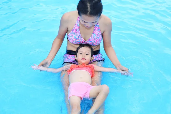 Досить маленька дівчинка з матір'ю в басейні на відкритому повітрі — стокове фото