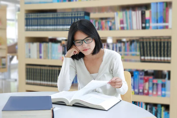 Azjatycki student czytania książki w bibliotece — Zdjęcie stockowe