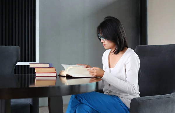 Asian woman reading a book in the library. — Stock Photo, Image