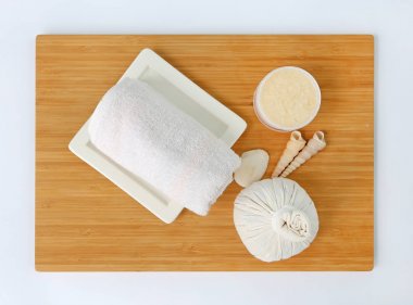 Havlu ve Salt Scrub, Spa konsept Bambu tahta karşı beyaz arka plan üzerinde topla sıkıştırma spa bitkisel