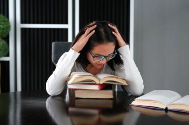 Asyalı kadın kütüphanede kitap okuma.