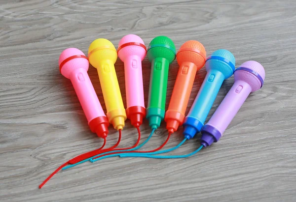 Micrófono de plástico colorido sobre fondo de madera, juguete para niños — Foto de Stock