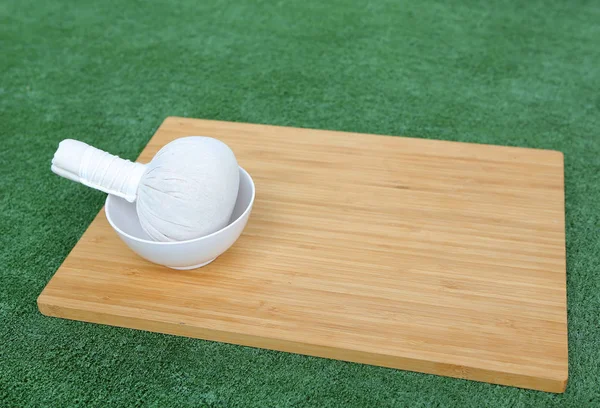 Bylinné kompresní míč pro lázeňské léčby na bambusové dřevěné desce proti sněhová vločka — Stock fotografie