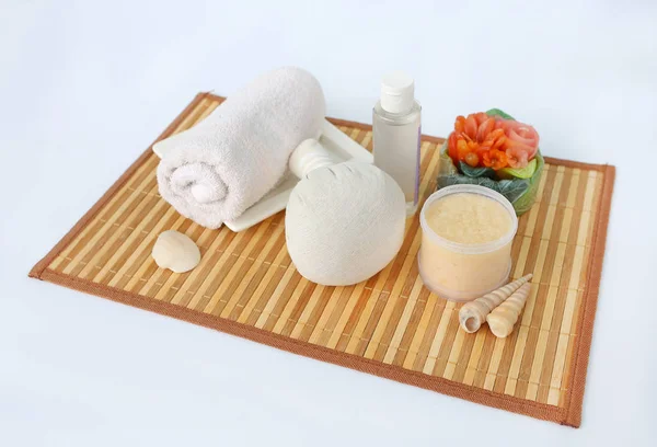 Balón de compresión de hierbas Spa con toallas y exfoliante de sal, concepto de spa en estera de tejido de bambú sobre fondo blanco — Foto de Stock