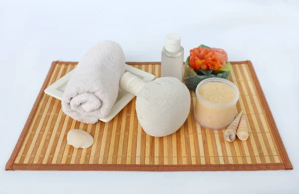 Balón de compresión de hierbas Spa con toallas y exfoliante de sal, concepto de spa en estera de tejido de bambú sobre fondo blanco — Foto de Stock