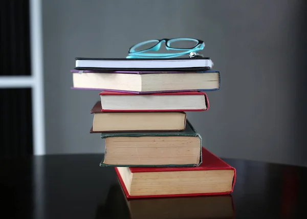 Pilha de livros de capa dura com óculos na mesa de madeira. Fundo de educação . — Fotografia de Stock
