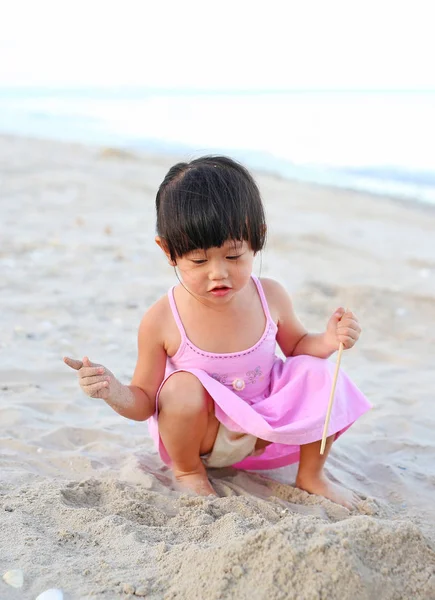 Gadis kecil bermain pasir di pantai. — Stok Foto