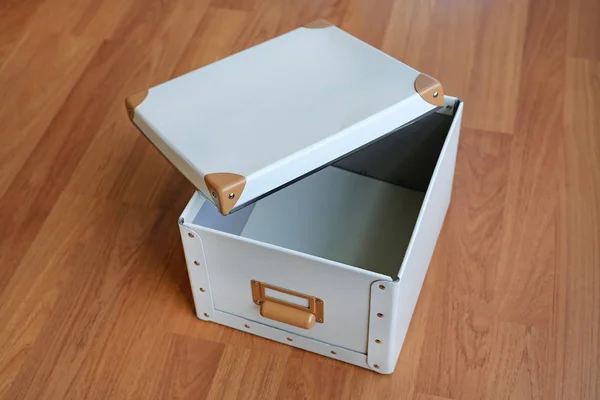 Open white blank plastic storage box on wood floor — Stock Photo, Image