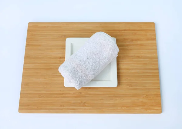 Wellness-Konzept, Handtücher auf Bambusbrett vor weißem Hintergrund — Stockfoto