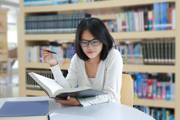 Azjatycki student czytania książki w bibliotece — Zdjęcie stockowe