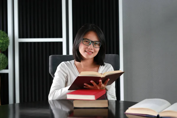 Mujer asiática leyendo un libro en la biblioteca . — Foto de Stock