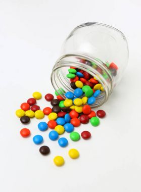 Beyaz bir arka plan üzerinde renkli şeker kaplı çikolatalı smarties