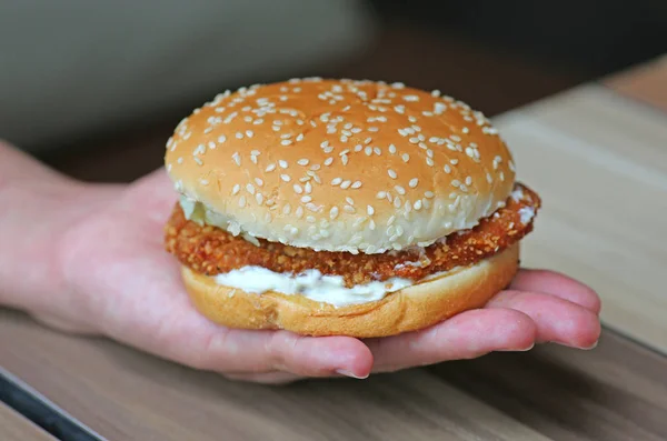 Hambúrguer apetitoso na mão — Fotografia de Stock