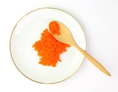 Turuncu tobiko ya da yumurta karides beyaz plaka ve tahta kaşık