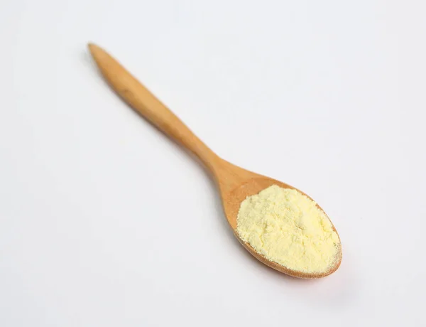 Leche en polvo en cuchara de madera sobre fondo blanco — Foto de Stock