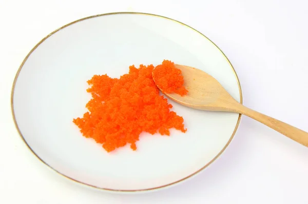 Tobiko oranye atau udang telur di piring putih dan sendok kayu — Stok Foto