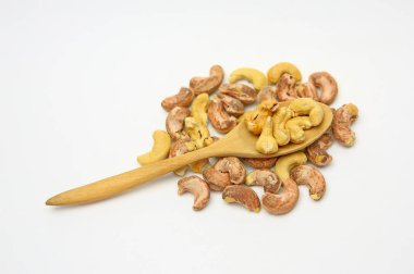 Kaşu fındık kaşu fındık beyaz arka plan üzerinde yığın karşı bir tahta kaşık içinde