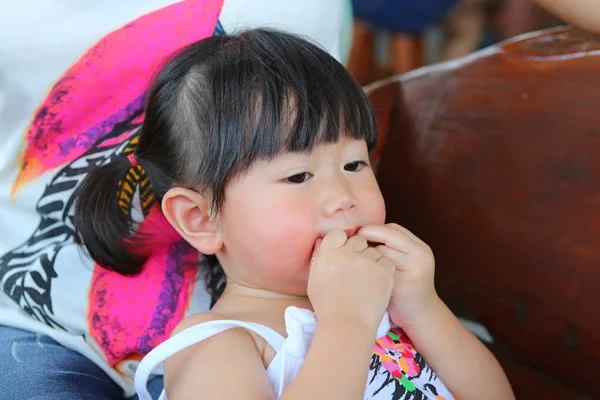 Portrait of one year old and six month child, Baby girl lying on mother knee and eating a chicken wing — Stock Photo, Image