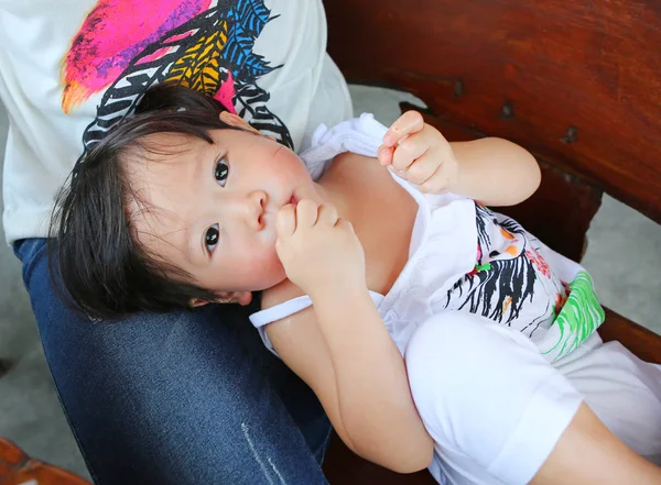 Retrato de uma criança de um ano e seis meses, bebê deitado no joelho da mãe e comendo uma asa de frango — Fotografia de Stock