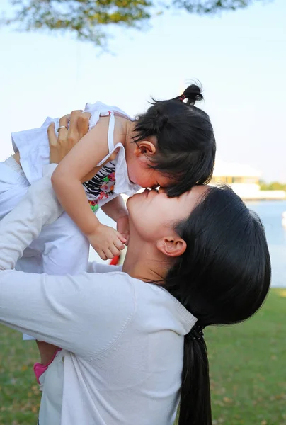 Dziewczynka azjatyckich w matka przytulić w parku — Zdjęcie stockowe
