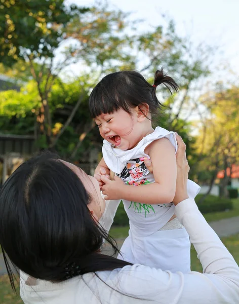 Nahaufnahme Mutter hält ihr Baby lachend und weinend im Park — Stockfoto