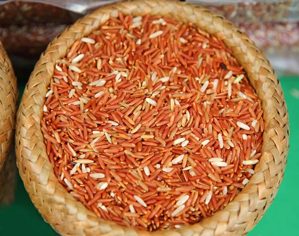 Asijské červená jasmínová rýže v bambusové tkaniny koš — Stock fotografie