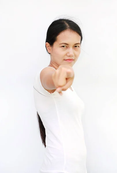 Mladá asijská žena v tričko ukazováčkem na vás na bílém pozadí, vybrané zaměření na její obličej — Stock fotografie