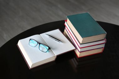 Açık kitap, ciltli kitap ve ahşap masa gözlük. Eğitim arka plan.