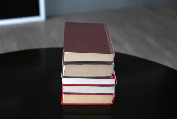 Stack of hardcover books on wooden table — Stock Photo, Image