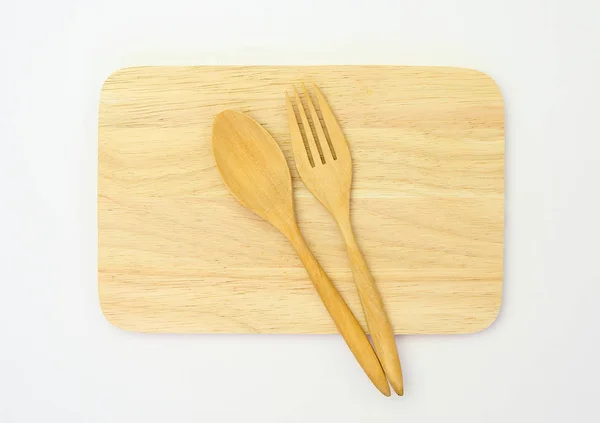 Wooden spoon and fork on wooden board against white background — Stock Photo, Image
