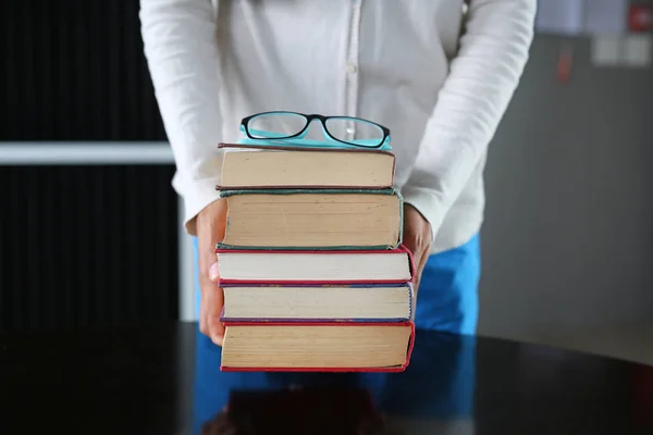 Montón de libros de tapa dura con gafas en manos de mujer. Formación profesional . — Foto de Stock