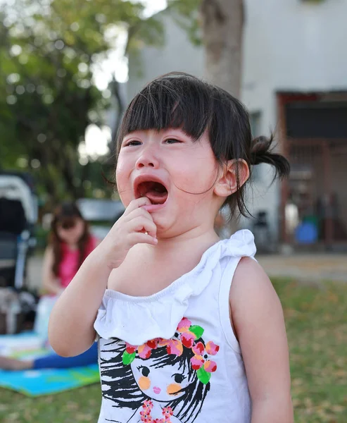 Primer plano linda niña llorando en el parque . — Foto de Stock