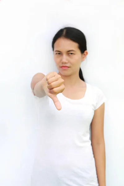 Mulher asiática em T-Shirt mostrando para baixo no fundo branco, foco selecionado em sua mão — Fotografia de Stock