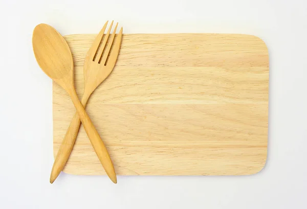 Wooden spoon and fork on wooden board against white background — Stock Photo, Image