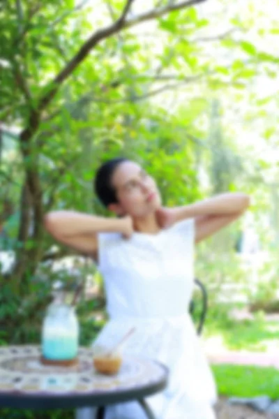 Blur imagen de Joven mujer asiática sentado y relajarse en el café al aire libre —  Fotos de Stock