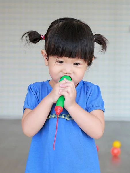 亚洲儿童在孩子房间玩塑料麦克风 — 图库照片