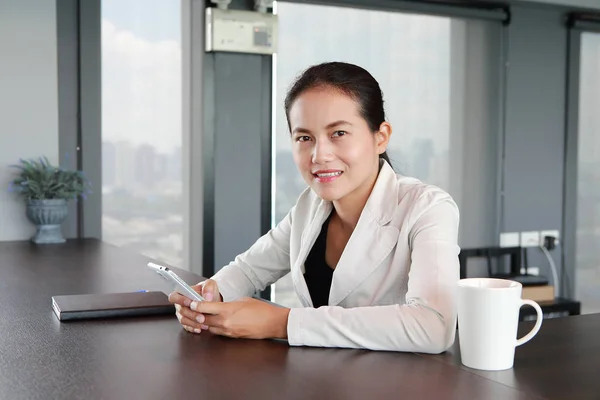 Jeune femme d'affaires assise à la table sur le lieu de travail au bureau par téléphone — Photo