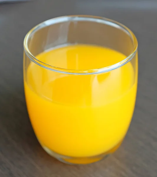 Стаканы желтый ликер алкогольный коктейль жидкий сок на деревянный стол — стоковое фото