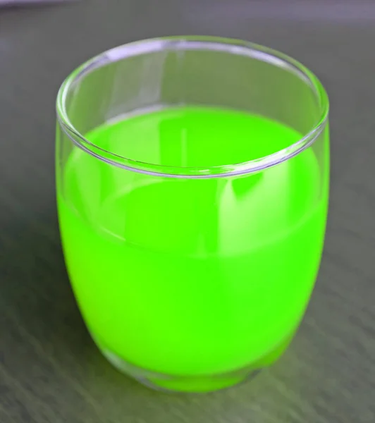 Окуляри зелений лікер алкогольний коктейль напій рідкий сік на дерев'яному столі — стокове фото