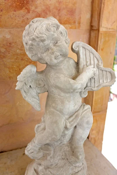 Statua Cupido in un giardino — Foto Stock