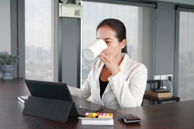 Kafede kahve içme ve zevk dizüstü bilgisayar, tablet, akıllı telefon ile oturan genç Asyalı kadın