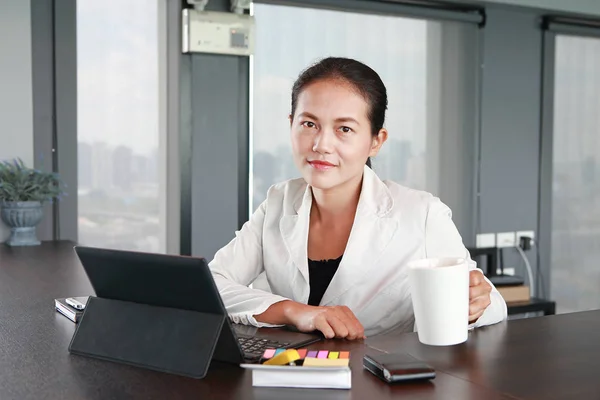 Young businesswoman sitting at the table on workplace in office with laptop computer — Stock Photo, Image