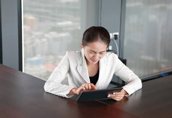 Fiatal üzletasszony ül az asztalnál a munkahelyi hivatalban a játék tabletta — Stock Fotó